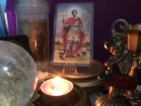 a tarot card on a table next to a candle